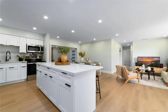 a kitchen with stainless steel appliances kitchen island granite countertop a sink and cabinets