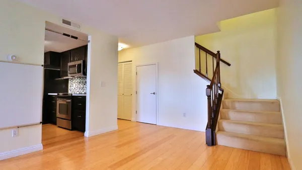 a view of a hallway with wooden floor and entryway