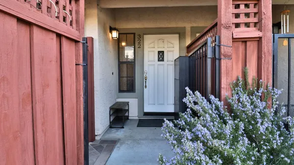 a view of a house with a potted plant and floor to ceiling window