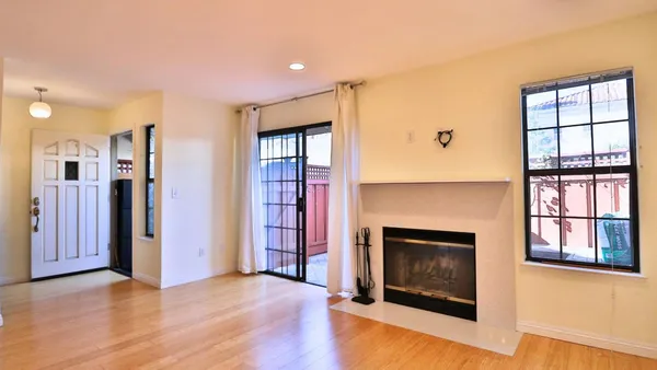 wooden floor fireplace and windows in an empty room