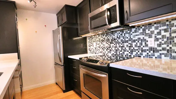a kitchen with granite countertop cabinets and black appliances