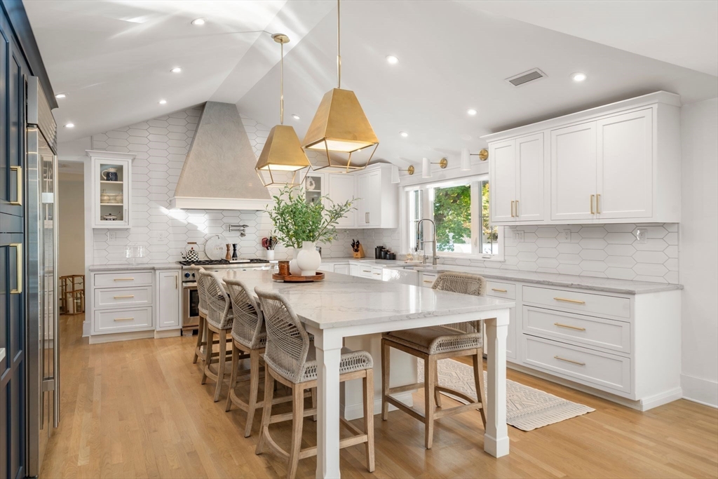 23 Tophet Road Lynnfield, MA 01940 - Photo 10 of 42 a kitchen with stainless steel appliances kitchen island granite countertop a table chairs sink and cabinets