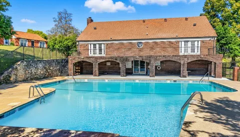 a view of house with swimming pool yard and outdoor seating