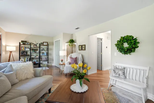 a living room with furniture flowers and a chandelier