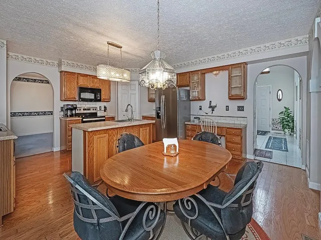 a dining room with furniture a chandelier and wooden floor