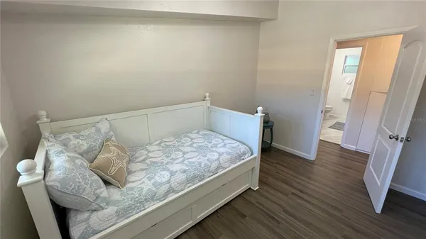 a bedroom with a bed and wooden floor