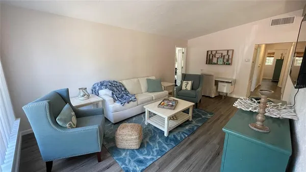 a living room with furniture rug and wooden floor