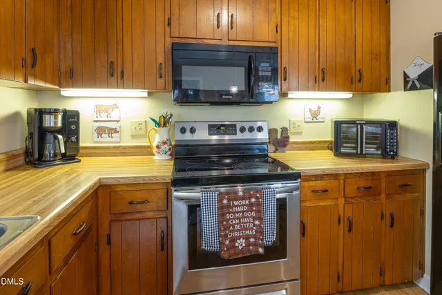 a kitchen with stainless steel appliances granite countertop a stove a sink and a microwave
