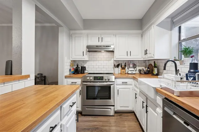 a kitchen with white cabinets stainless steel appliances and sink