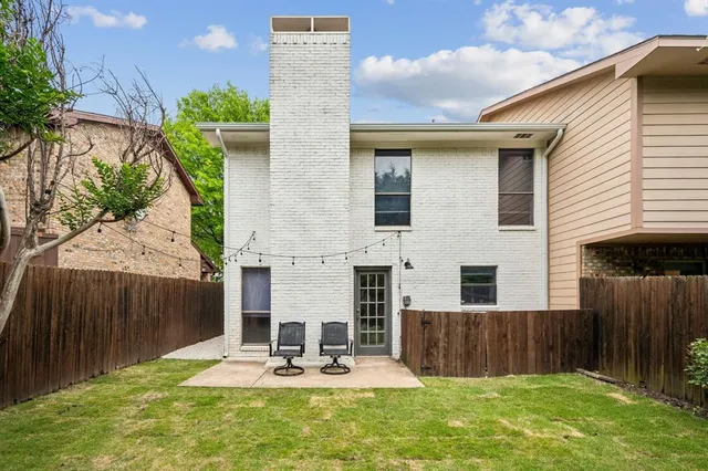 a view of house with backyard and sitting area