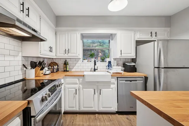 a kitchen with stainless steel appliances granite countertop a sink stove and refrigerator