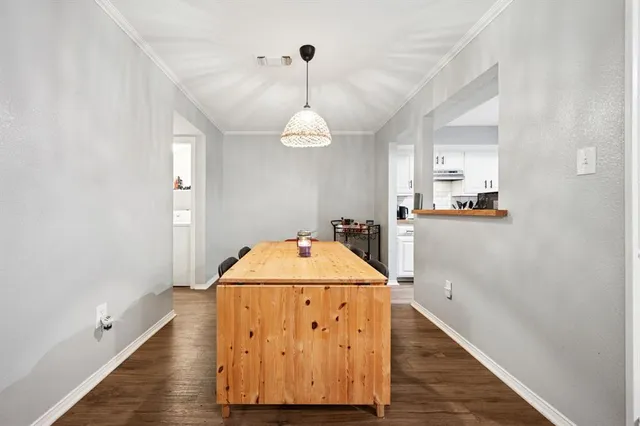 a view of a hallway with a dining table chairs and chandelier