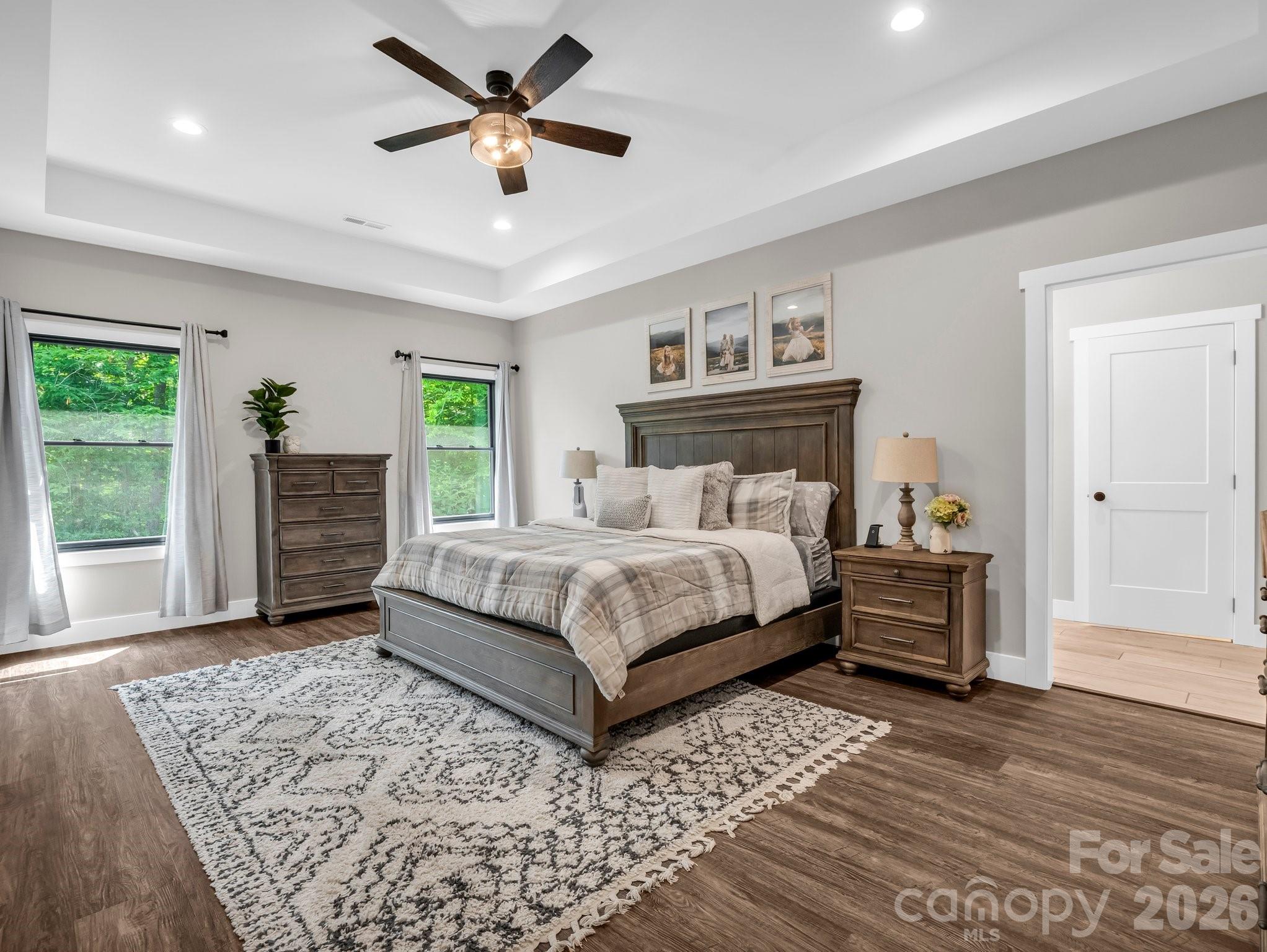 5717 Turnpike Road Horse Shoe, NC 28742 - Photo 20 of 36 a bedroom with a large bed and a chandelier