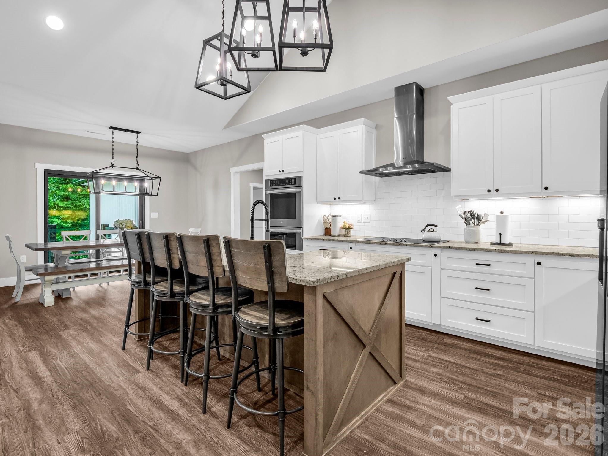 5717 Turnpike Road Horse Shoe, NC 28742 - Photo 26 of 36 a kitchen with stainless steel appliances a dining table chairs refrigerator and cabinets