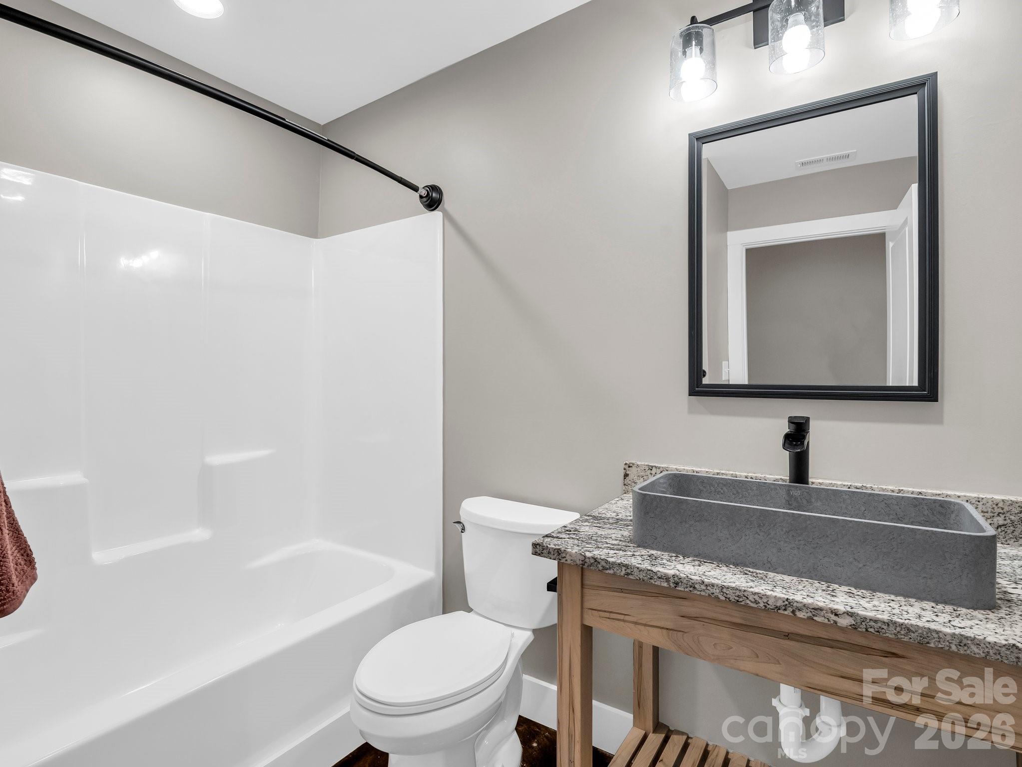 5717 Turnpike Road Horse Shoe, NC 28742 - Photo 7 of 36 a bathroom with a granite countertop sink toilet and mirror