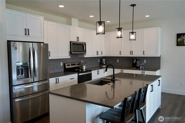 a kitchen with stainless steel appliances a sink stove and refrigerator