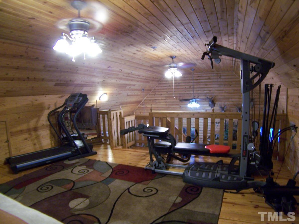 239 Rocky Ridge Road Leasburg, NC 27291 - Photo 22 of 23 a living room with lots of furniture and gym equipment