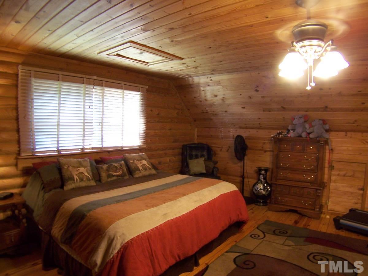 239 Rocky Ridge Road Leasburg, NC 27291 - Photo 23 of 23 a bedroom with a bed and a chandelier