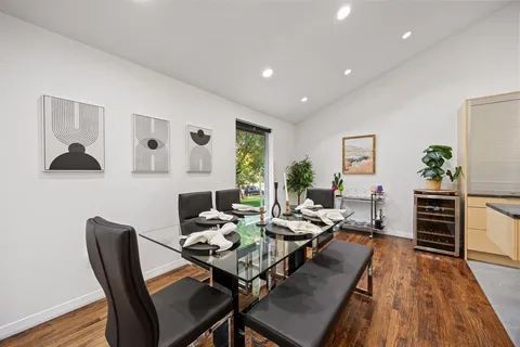 a living room with furniture a wooden floor and kitchen view