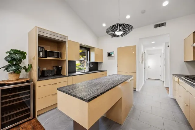 a large kitchen with stainless steel appliances granite countertop a stove a sink and a microwave