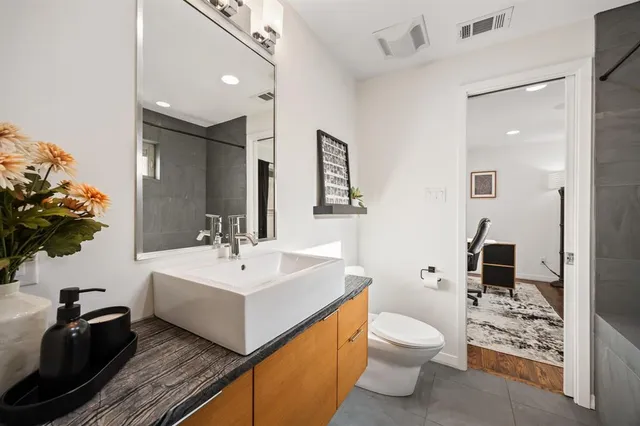 a bathroom with a granite countertop tub sink a mirror and a shower