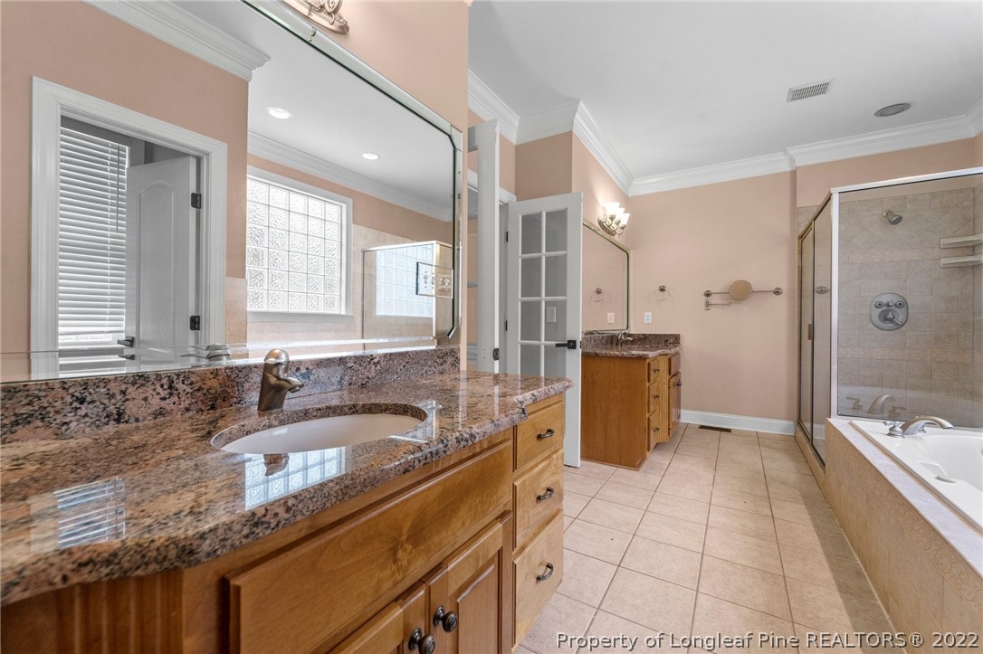 255 Falling Water Road Spring Lake, NC 28390 - Photo 25 of 39 a bathroom with a granite countertop sink mirror and a bathtub