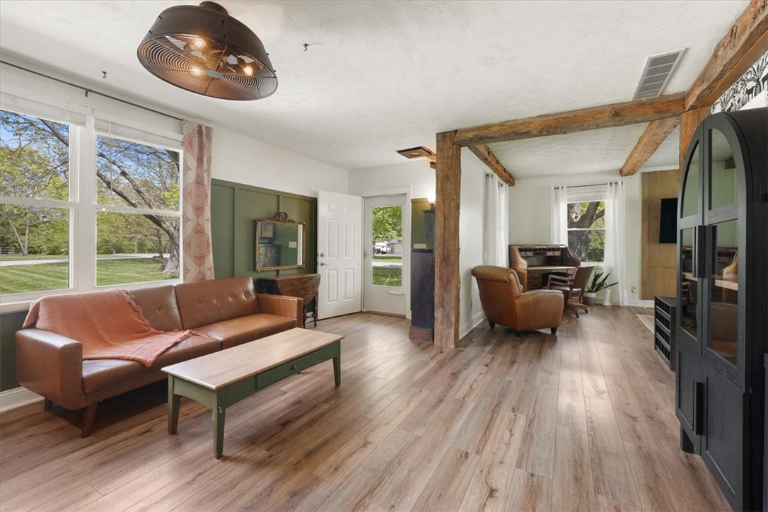 5120 Wheelock Road Troy, OH 45373 - Photo 8 of 67 This inviting living area features exposed wooden beams and large windows, creating a bright and airy atmosphere.