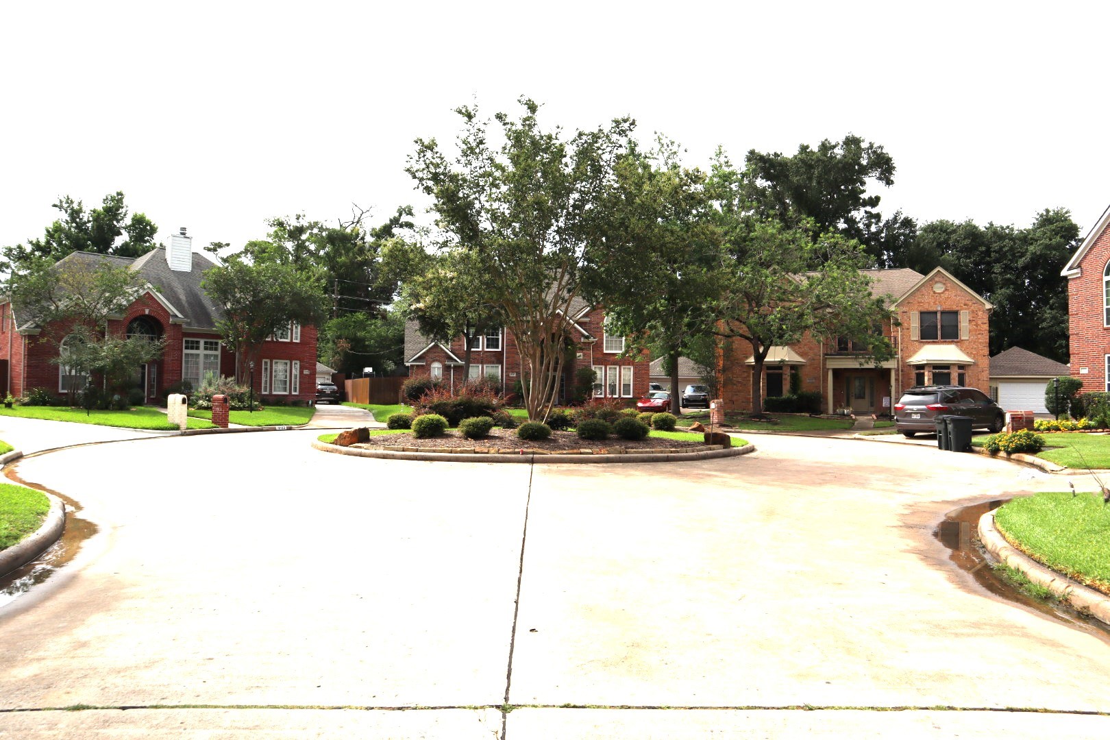 19114 Emory Trail Spring, TX 77388 - Photo 32 of 32 This view showcases a peaceful suburban cul-de-sac with well-maintained brick homes, lush greenery, and a tidy central island. Perfect for families seeking a quiet, community-oriented neighborhood.