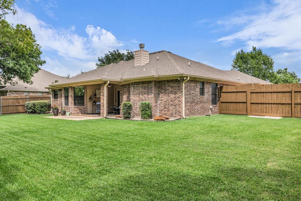 814 Springdale Circle Lorena, TX 76655 - Photo 32 of 37 Expansive grassy yard featuring a brick exterior, covered patio, privacy fencing, and mature landscaping