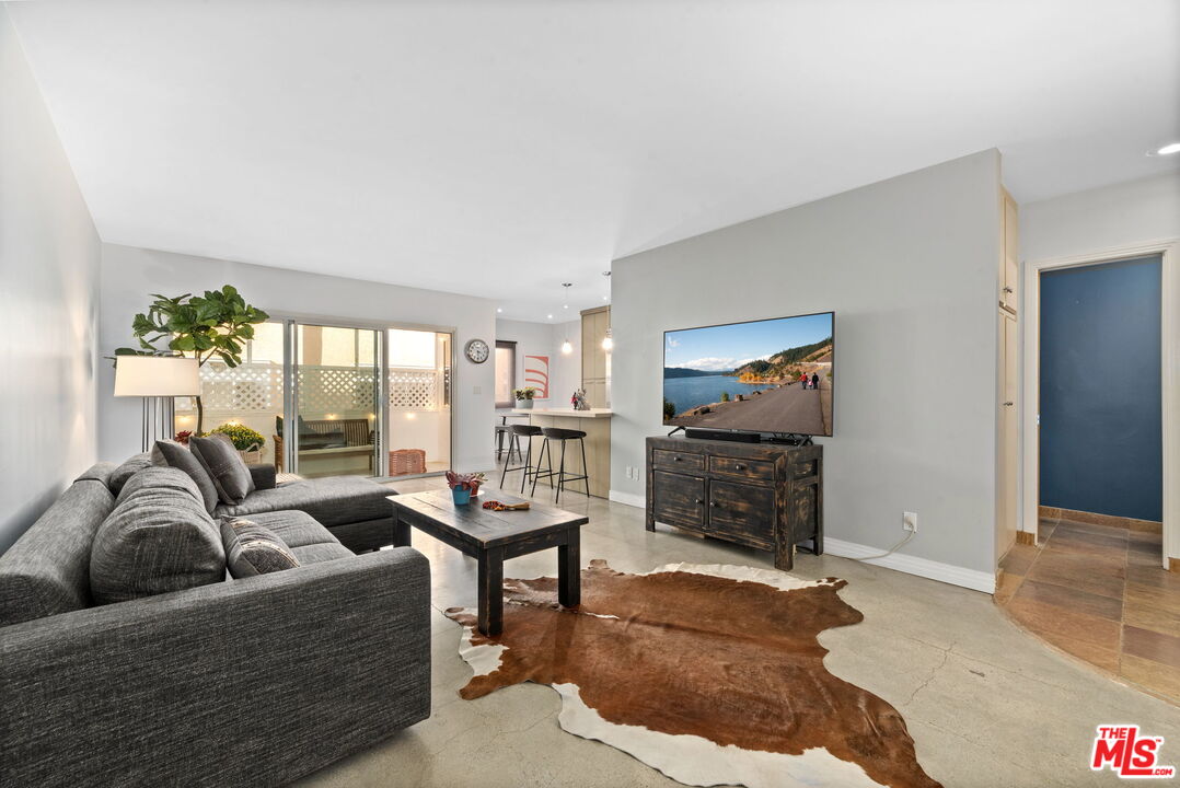 8710 Delgany Avenue, Unit 3 Playa del Rey, CA 90293 - Photo 4 of 21 a living room with furniture a flat screen tv and a fireplace