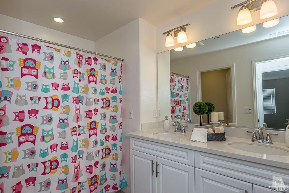 4885 Edenbridge Road Moorpark, CA 93021 - Photo 21 of 30 a bathroom with a sink a mirror and shower curtain