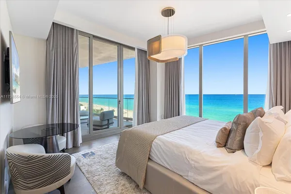 a bedroom with a bed a chandelier and a window
