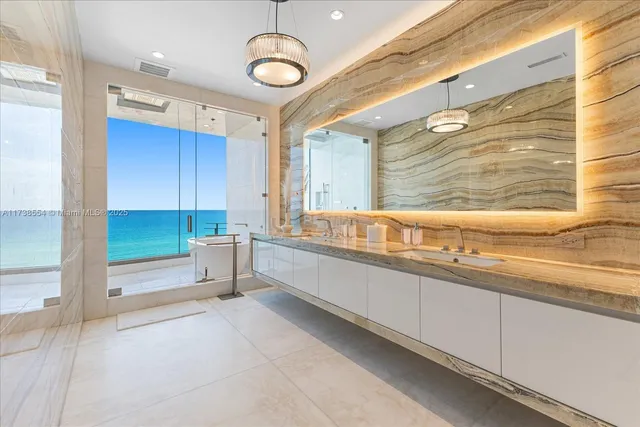 a large white kitchen with a large window and stainless steel appliances