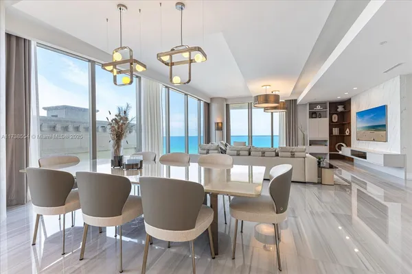 a view of a dining room with furniture a chandelier and wooden floor