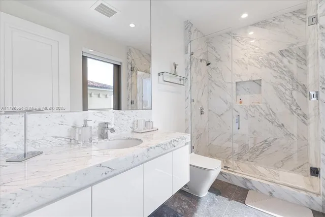 a bathroom with a granite countertop sink toilet and shower