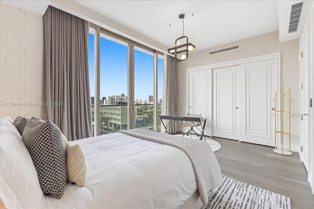 a bedroom with a large bed and a chandelier