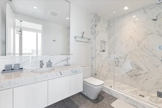 a bathroom with a double vanity sink toilet and shower