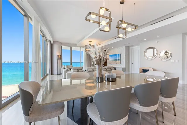 a dining room with wooden floor a chandelier a glass table and chairs