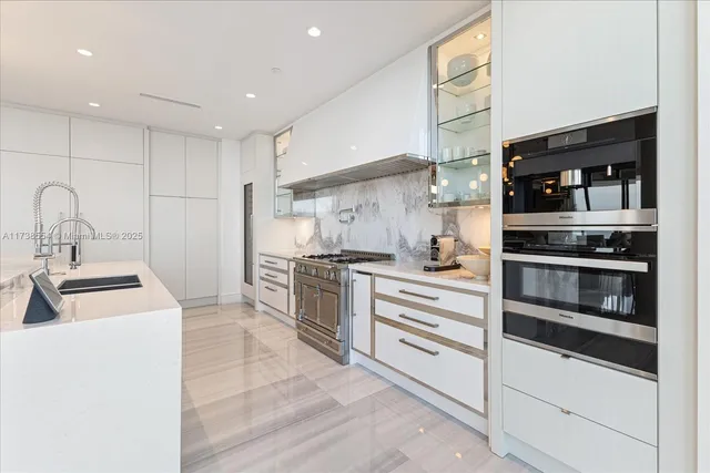 a kitchen with white cabinets and stainless steel appliances