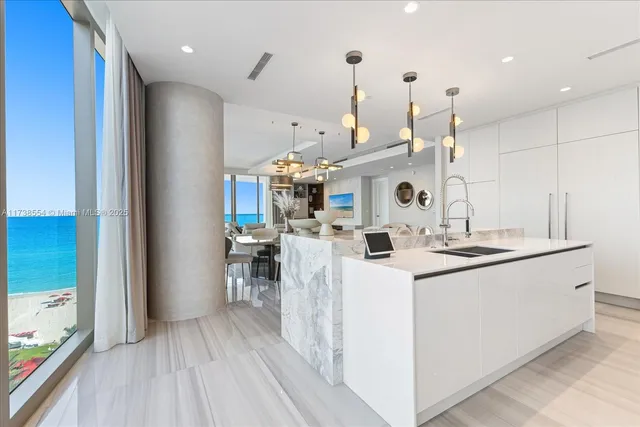a large white kitchen with refrigerator a sink dishwasher and a fireplace with wooden floor