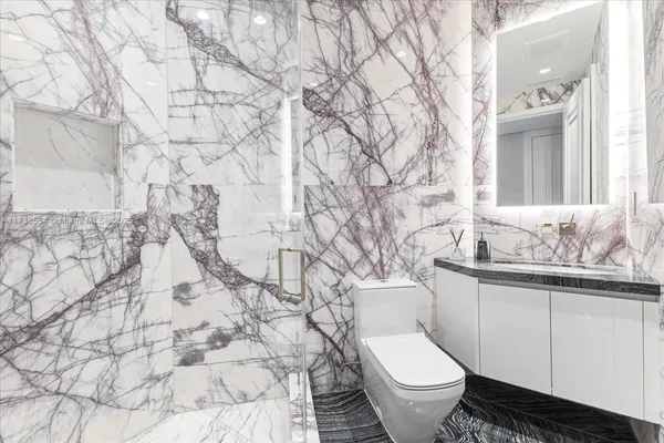 a white toilet sitting next to a bathroom sink