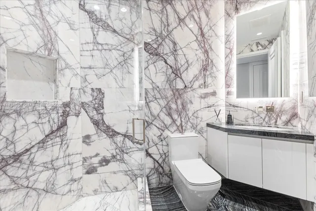 a white toilet sitting next to a bathroom sink