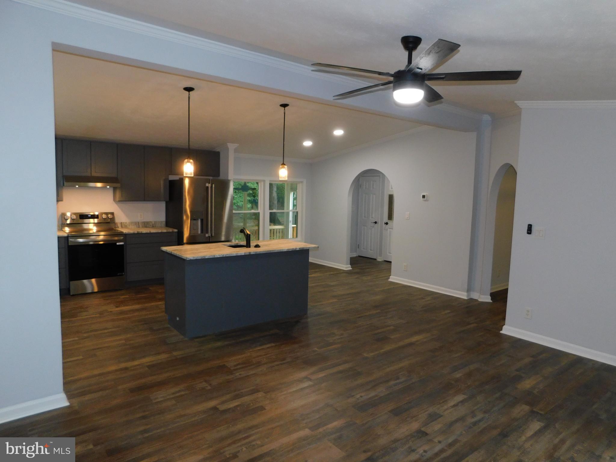 2608 Hunting Quarter Road Houston, DE 19954 - Photo 12 of 58 a view of a kitchen with a sink a fireplace and wooden floor