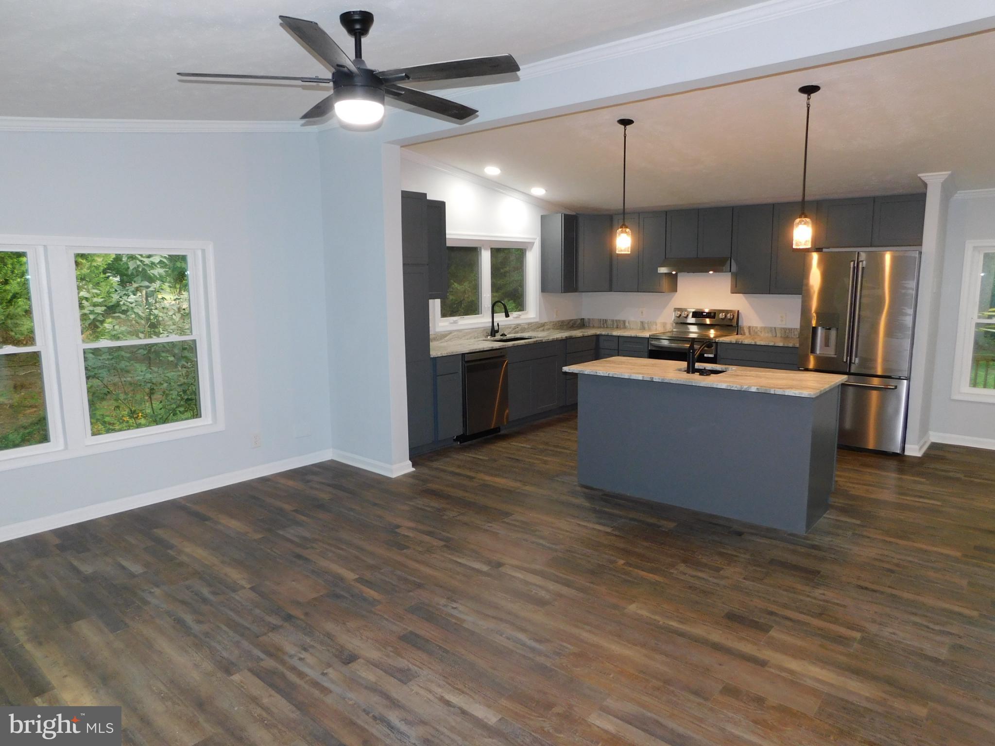 2608 Hunting Quarter Road Houston, DE 19954 - Photo 10 of 58 a kitchen with kitchen island granite countertop a stove and a wooden floor