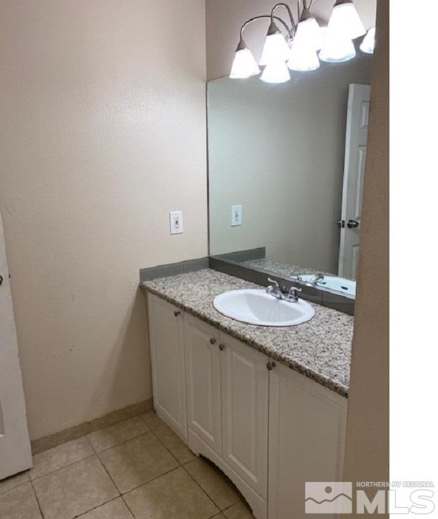 2555 Clear Acre Lane, Unit 933 Reno, NV 89512 - Photo 13 of 14 a bathroom with a granite countertop sink and a mirror