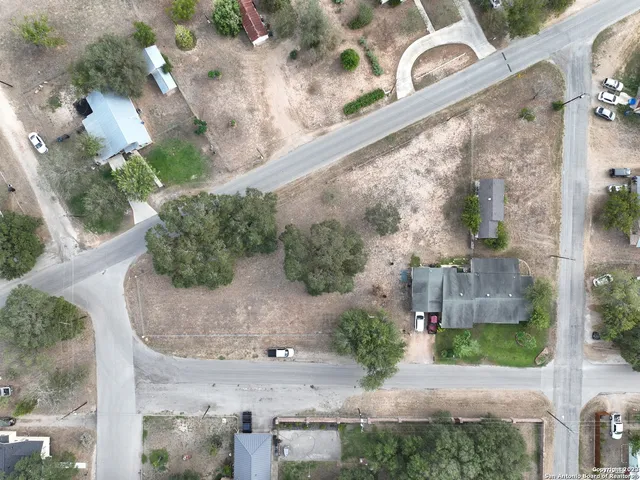 an aerial view of a house with a yard and a wooden bench