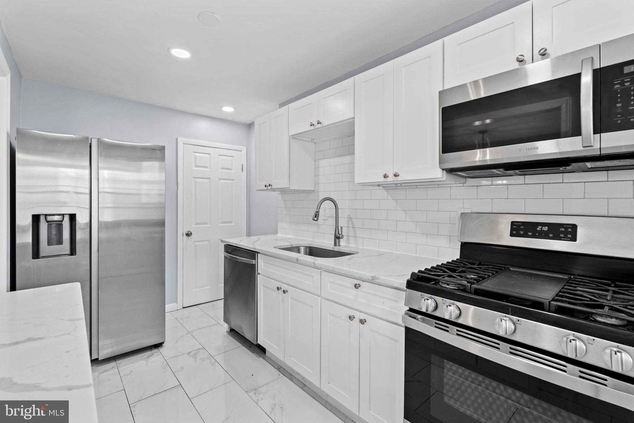 a kitchen with stainless steel appliances a sink a stove and microwave