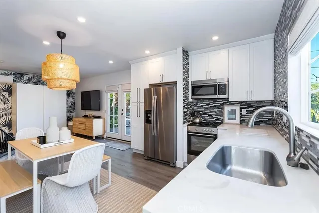 a kitchen with granite countertop a sink stainless steel appliances and cabinets