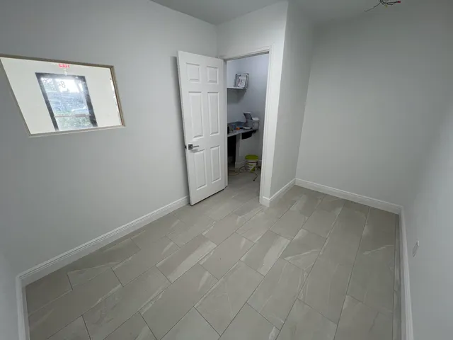 a view of empty room with window and refrigerator