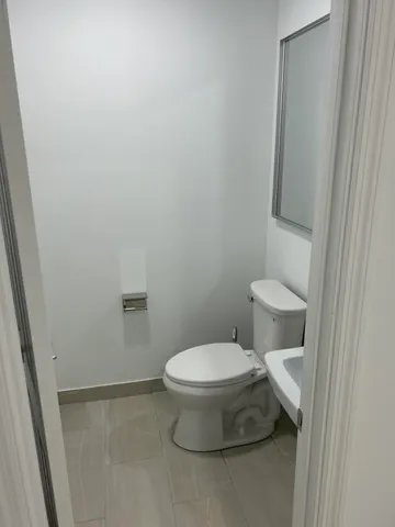 a white toilet sitting next to a shower